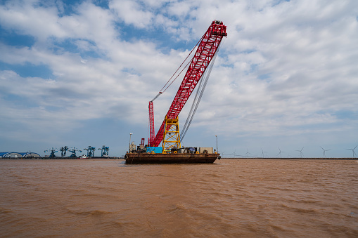 A lighter with heavy crane on the sea by Tra Vinh wind power farm - Dong Hai, Tra Vinh province, south Vietnam