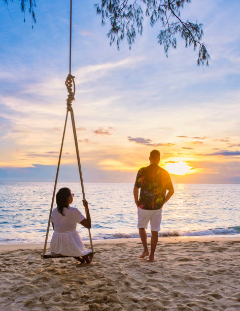 istock Couple watching sunset on a tropical beach 1436012408