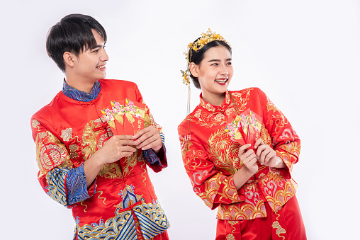 The Man and woman wear cheongsam glad to get the gift money from their relative in traditional day