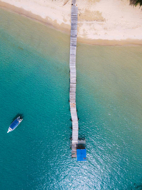 Drone view of wooden pier at a tropical Island Drone view of wooden pier at a tropical Island , couple on wooden pier jetty aerial stock pictures, royalty-free photos & images