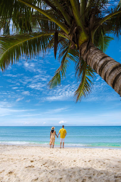 istock Couple walking on a tropical beach in Thailand 1436014023