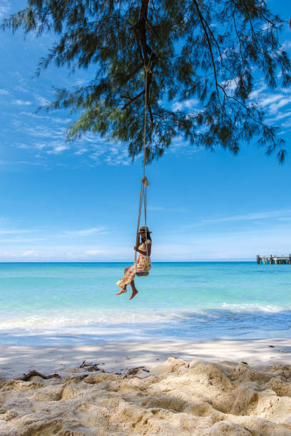 istock Women on a swing on a unspoiled beach in Thailand 1436014102