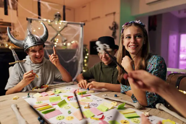 Photo of Family playing custom board / RPG game together at home.