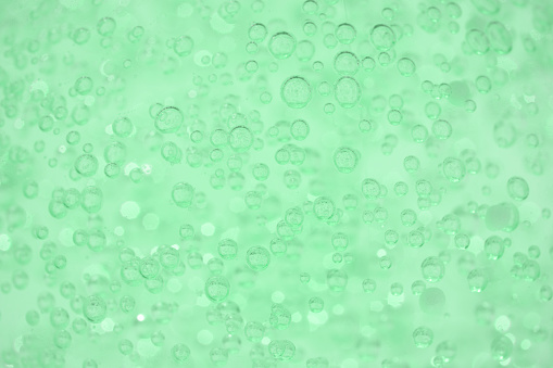 Texture of aloe vera cosmetic gel or face serum as background with bubbles and copy space. Natural cosmetic product, selective focus