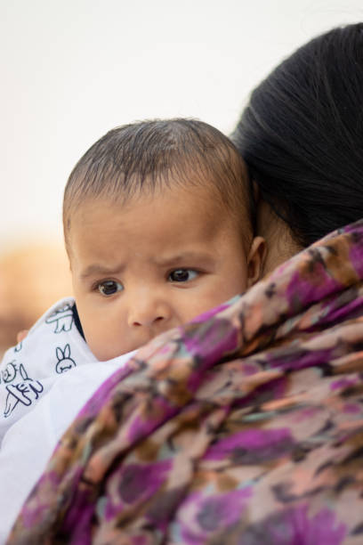 istock cute infant facial expression resting at mother shoulder from flat angle 1436029119
