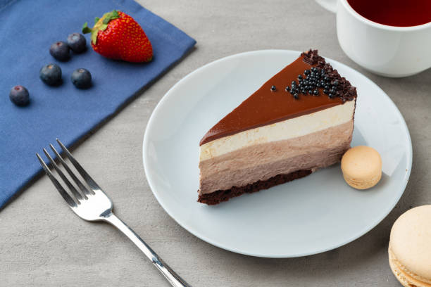 tre fette di torta al cioccolato su piatto bianco - chocolate mousse cake foto e immagini stock
