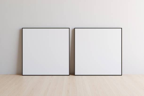 istock Two square blank picture canvases with thin black borders standing on wooden floor. Template for your content. 3D illustration. 1436031021