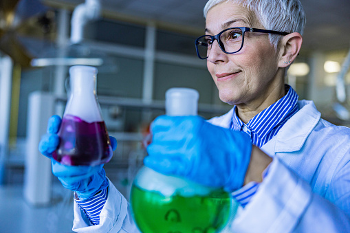 Crazy senior chemist working with chemical substances in laboratory.