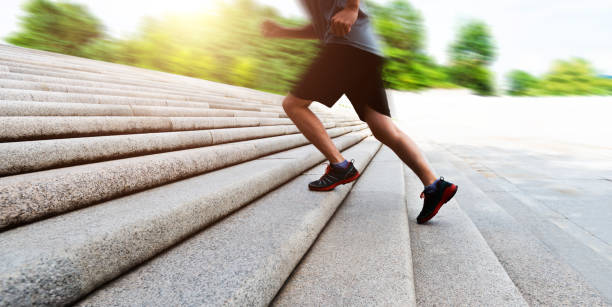 Low section of man running up stone stairway