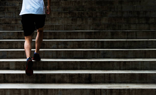 sección baja de joven corriendo por escaleras al aire libre - staircase running moving up jogging fotografías e imágenes de stock