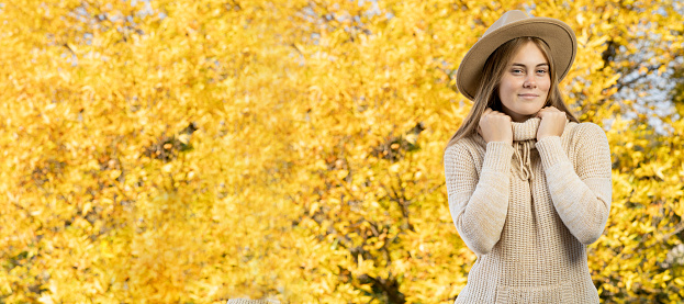 autumn woman standing over leaves and smiling. Banner