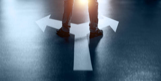 istock Businessman standing on two white direction arrows 1436032459