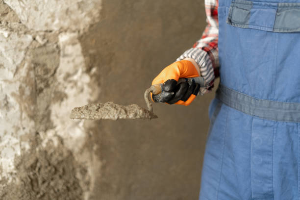 istock Hands man plasterer construction worker at work with trowel, plastering a wall cement mortar 1436032544