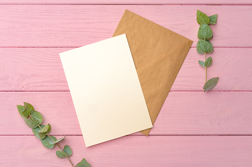 Envelope with letter on pink wooden background top view copy space