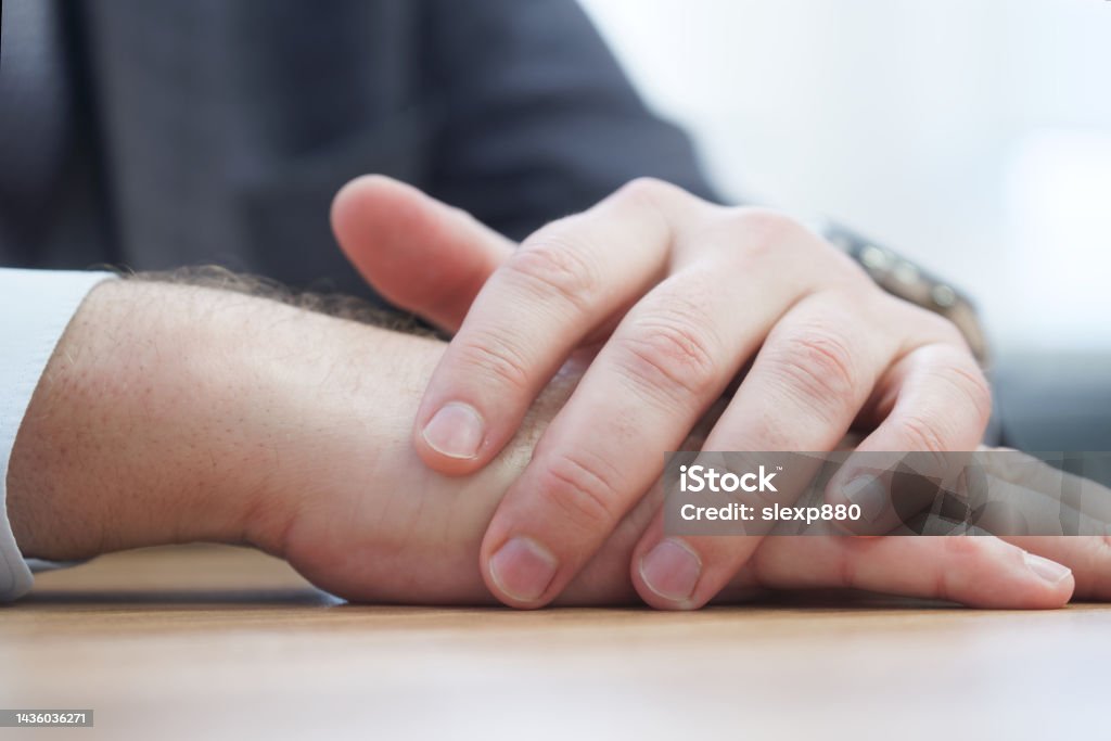 Folded hands of a politician, official or businessman on a negotiating table. Clerk, lawyer or deputy. Meeting participant. No face. Macro. Folded hands of a politician, official or businessman on a negotiating table. Clerk, lawyer or deputy. Meeting participant. No face. Macro. Close-up Adult Stock Photo