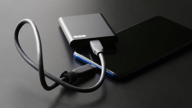 istock Black external portable SSD connected to a smartphone on a dark gradient background. Portable Solid State Drive. OTG interface. Concept of modern technology and the use of SSD disk. 1436036296