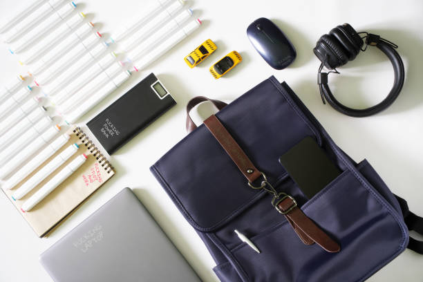 istock Backpack with a smartphone and a pen next to a laptop, power bank, mouse, notepad, felt-tip pens and toy cars. Captions: fucking study and work. Concept of fatigue and emotional exhaustion. 1436036404