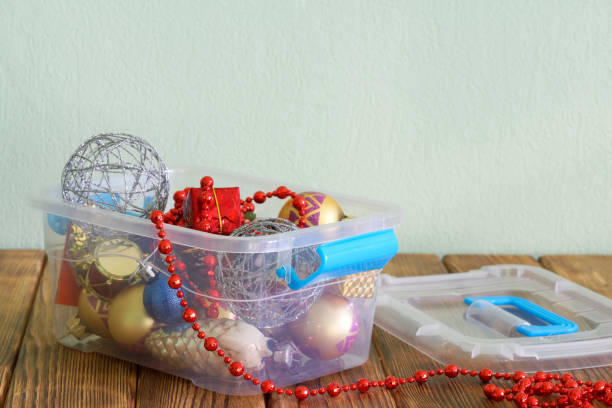 istock Old Christmas and New Year decorations in open plastic container on wooden plank rustic table and pale green. Concept of preparing for winter holidays and decorating the house. Copy space. 1436036458