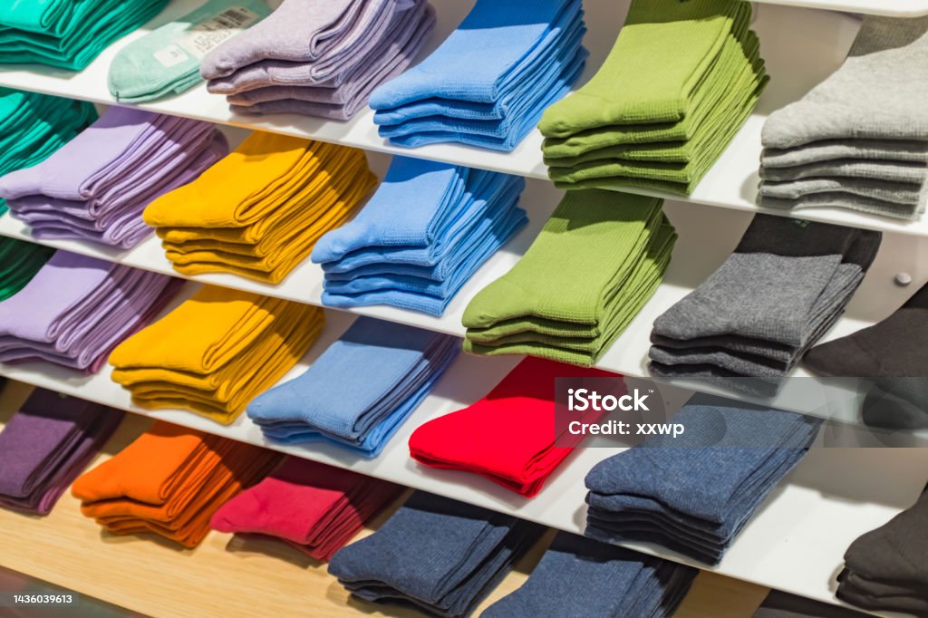 Multi colored socks stacked on shelves in the store Unisex Stock Photo