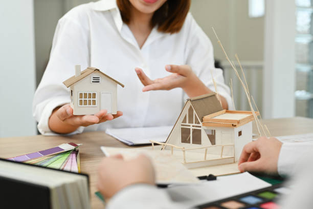 istock Cropped shot of two architects discussing construction project, working together on new building model in office. 1436042161