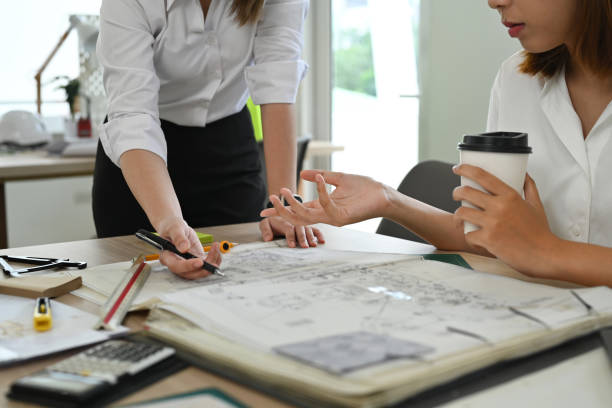istock Professional team of engineers or architects, brainstorming together over joint building project during meeting in modern office. 1436042245