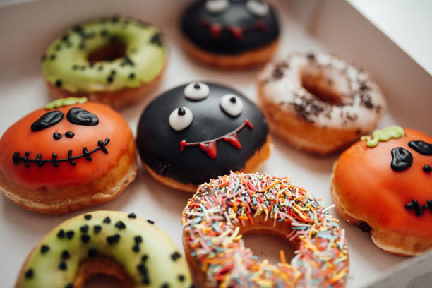 istock Assortment of halloween monsters with funny faces donuts in box at home interior 1436042641