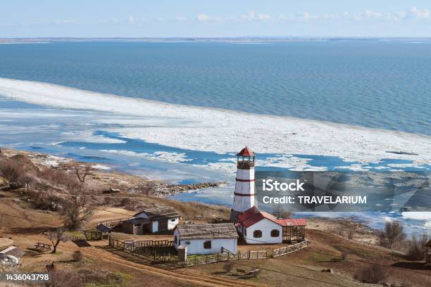 Atmospheric Romantic View To White Red Lighthouse With Farm Utility Houses In Merzhanovo Stock Photo - Download Image Now