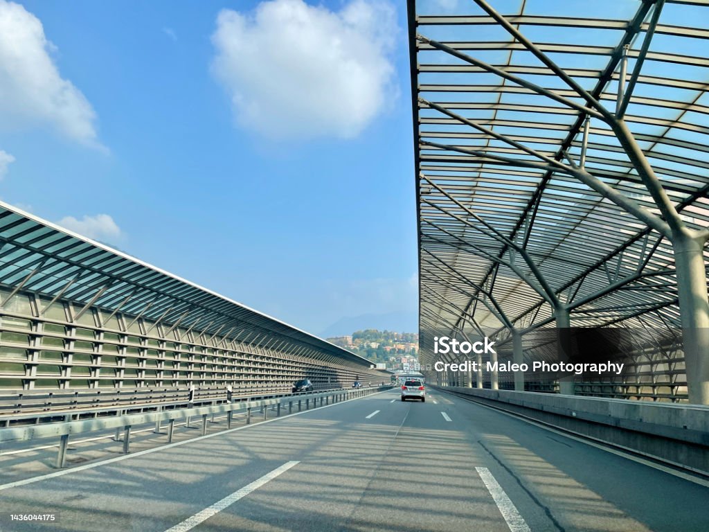 Traffic on Swiss highway with noise barrier close to border crossing Como Chiasso, Italy. Crossing Stock Photo