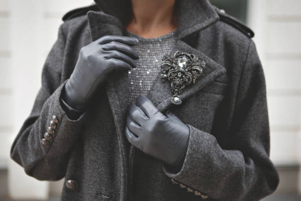 Female woolen warm gray double breasted coat and leather gloves. Stylish details of fashionista. Woman fashion outerwear stock photo