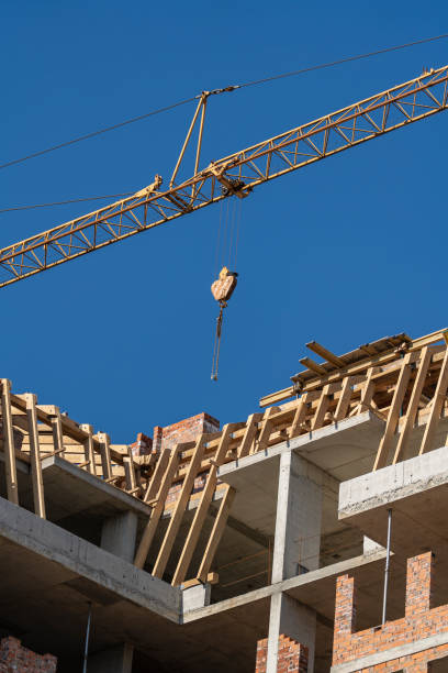 istock Crane and building under construction against sky. Crane works at a construction site 1436045365