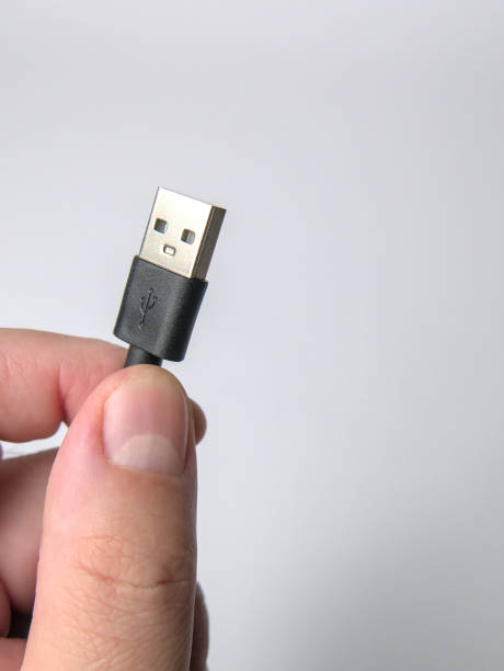 istock A man's hand holding unplugged USB cable, isolated on a white background 1436048244