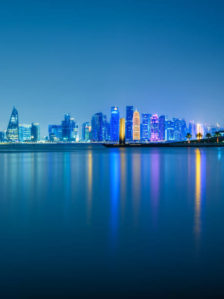 scatto verticale a lunga esposizione degli skyline della città di doha illuminati di notte a doha, qatar - middle eastern architecture foto e immagini stock