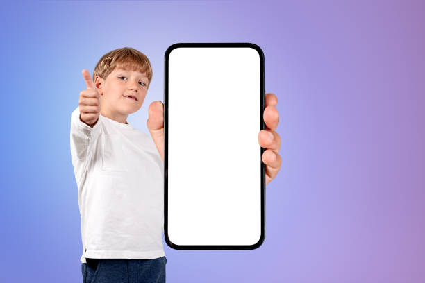 istock Kid showing thumb up and big phone mockup display on gradient background 1436050815