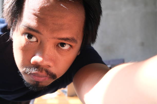 Southeast asian man close up fixing camera