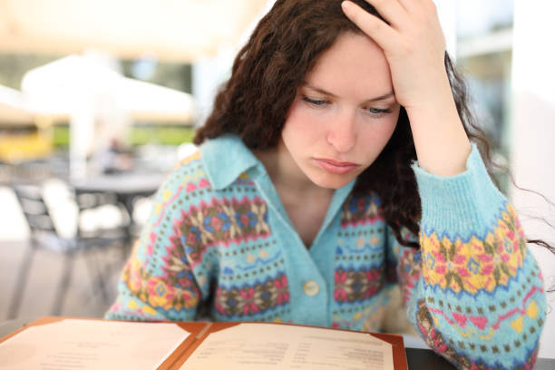 Stressed woman reading menu in a restaurant