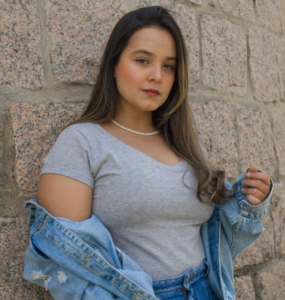 istock carefully makeuped latin caucasian woman standing ahead a stone wall while looking at camera with neutral expression 1436055660