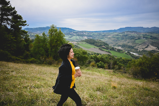 woman traveler drinks coffee with a view of the mountain landscape.