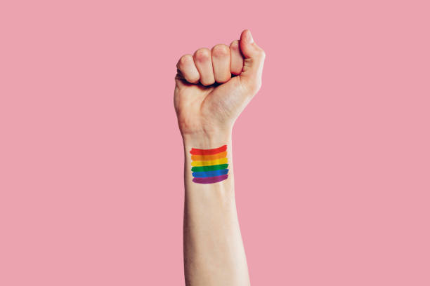 腕にレインボーフラッグが描かれたゲイの男性の手 - homosexual rainbow gay pride flag flag ストックフォトと画像