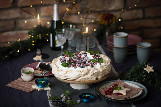 Christmas cake Pavlova Christmas cake Pavlova with berries decorated on dark blue background with Christmas decoration pavlova stock pictures, royalty-free photos & images