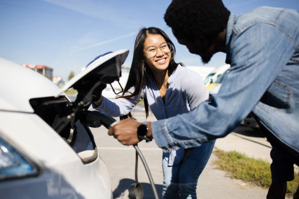 Young couple on a road trip charging their electric camper