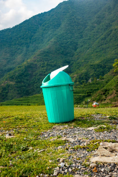 a plastic garbage bin in the middle of a green meadow with mountains in the background. uttarakhand india. - farmhouse the natural world meadow pasture imagens e fotografias de stock