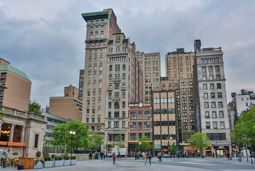 New York City, United States of America - May 6, 2017. Block of buildings on Union Square West in New York City. The view includes Bank of the Metropolis Building, Decker Building, 35 Union Square W and Hartford Building. View at dusk, with people and commercial properties.