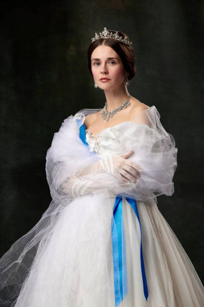 jeune reine. portrait d’adorable fille à l’image d’une personne royale médiévale en robe de style renaissance isolée sur fond sombre. comparaison des époques, beauté, histoire, art - princess women duchesses renaissance photos et images de collection