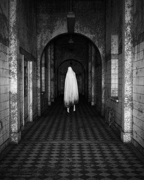 istock Floating Ghost in a Asylum Halloween Dark Black and White Film Grain Analogue Aesthetic Gothic Building with Ghost Hunters Camera Flash 1436070640