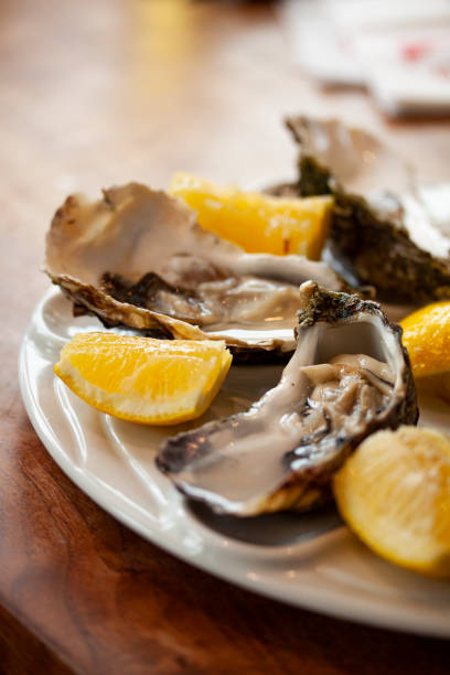 istock Fresh oysters close-up on a white plate, served table with lemon. 1436071922