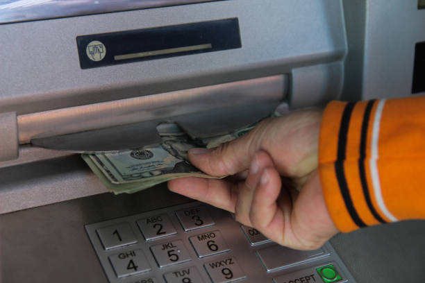 istock A man takes dollars from an ATM 1436072037