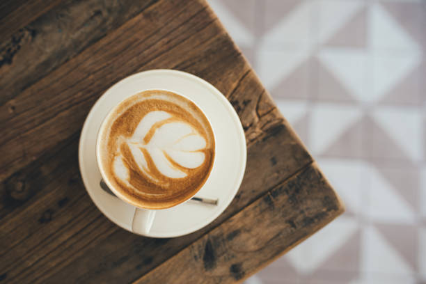 istock White cup with fresh cappuccino on wooden background 1436074042