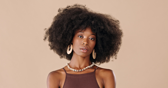 Mujer elegante, maquillada y negra con joyas de diseño contra un fondo de estudio de maquetas marrones. Retrato de una modelo africana con peinado afro, cosméticos de lujo y moda con espacio de maqueta photo