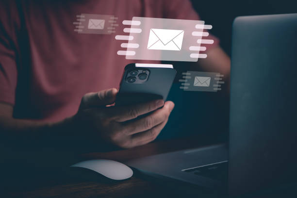 istock Businessman hands using Mobile Phone typing on keyboard and surfing the internet on office table with email icon, email marketing concept, send e-mail or news letter, online working internet network. 1436077773