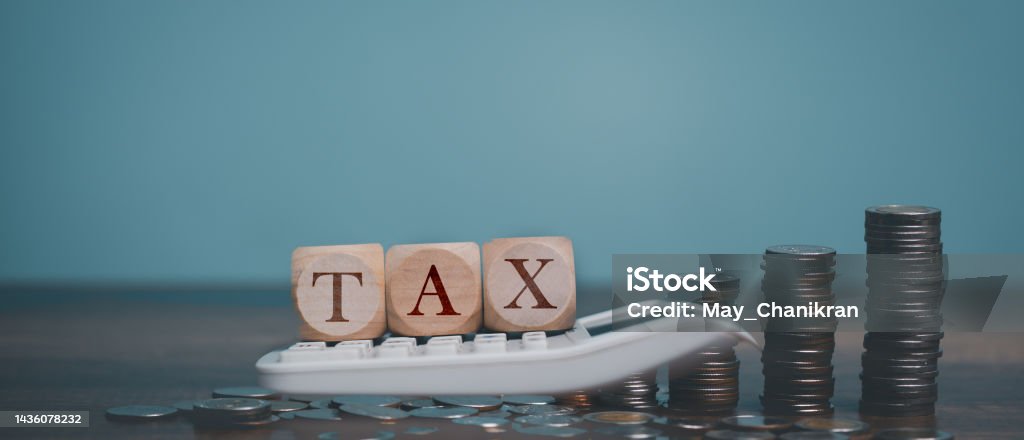 Calculate money for TAX with Calculator, wooden tax block, coins and copy space. Tax Stock Photo